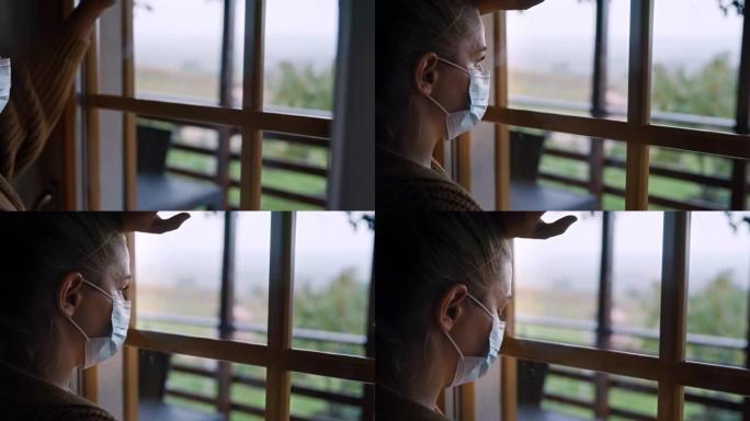 SLO MO女人戴着面具，透过窗户看，回忆新型冠状病毒肺炎禁闭期间的自由