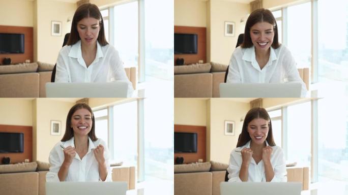 快乐的漂亮女人在笔记本电脑上阅读好消息感到喜出望外