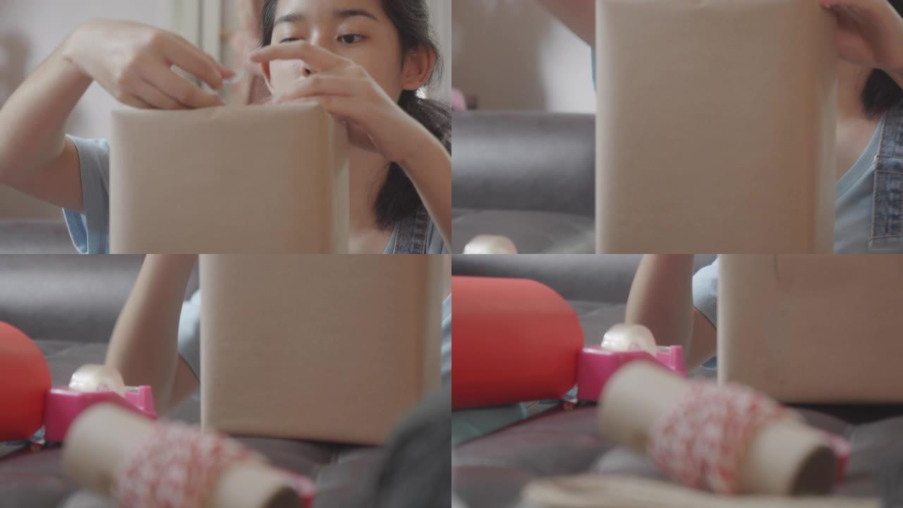向上倾斜和铜: 亚洲年轻少女制作手工物品护理包。可爱的女孩打包一个包装箱，准备从远处寄给她的家人或朋