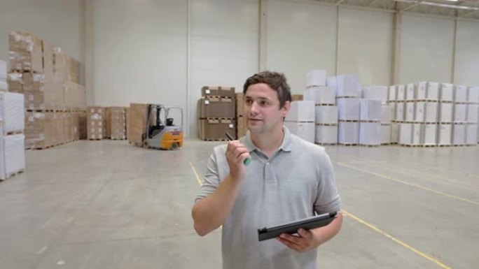一个数字平板电脑在仓库里用对讲机说话的人