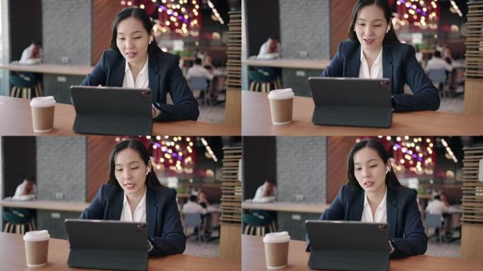 女商人在咖啡馆的数字平板电脑上进行视频通话会议，进行视频通话以与同事联系