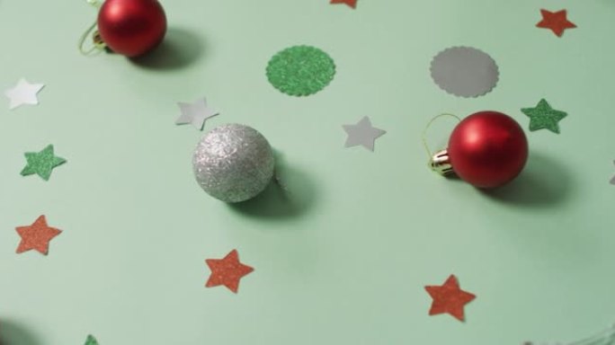绿色背景上有银色和红色摆设的圣诞装饰品
