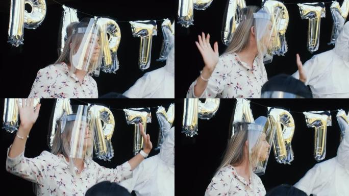 在有趣的朋友生日派对上，特写快乐的年轻白人白人金发女子在新型冠状病毒肺炎安全面罩中跳舞。