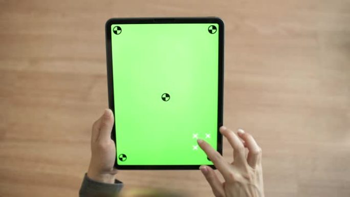 在家里的办公桌上使用带有绿色屏幕的数字平板电脑的特写手