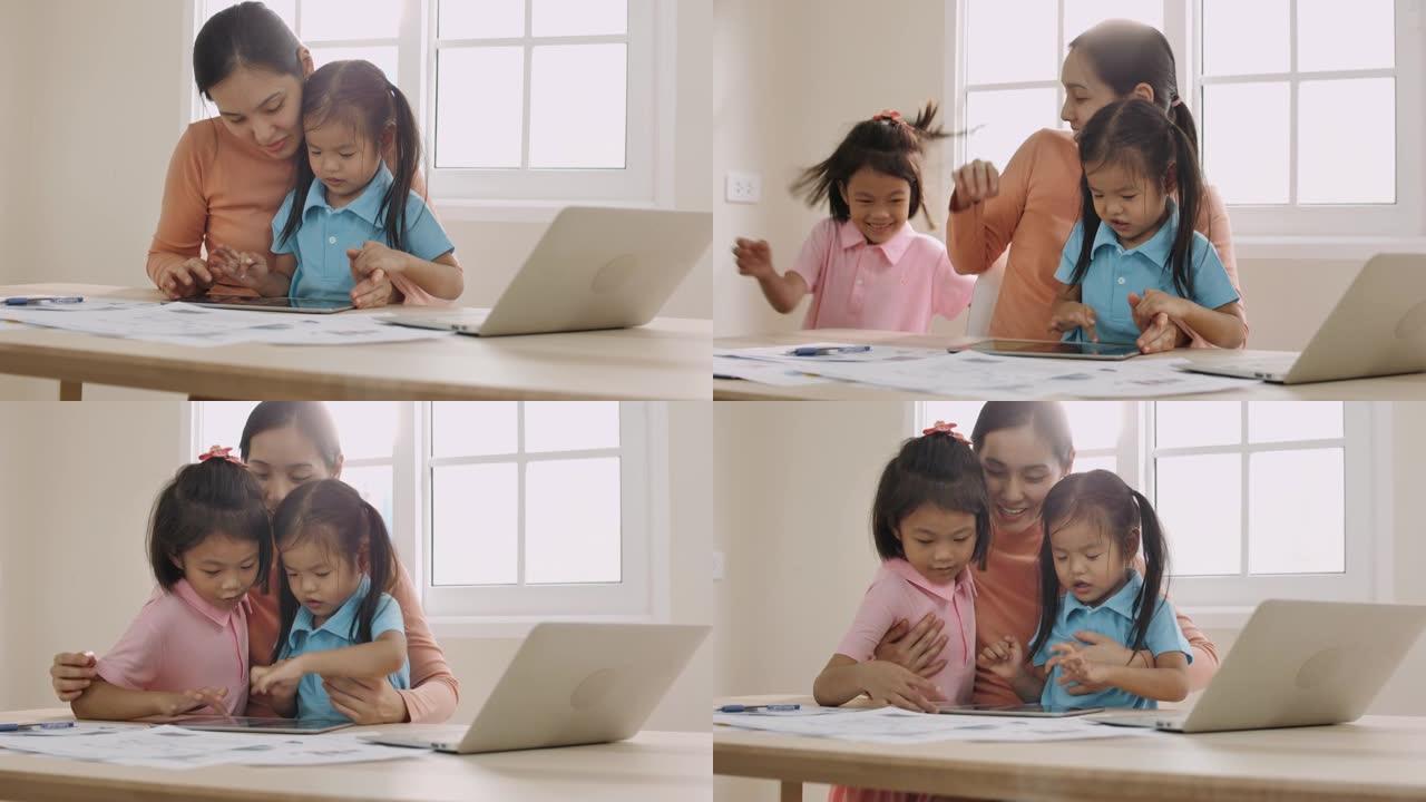 年轻的母亲与女儿一起使用计算机在家工作