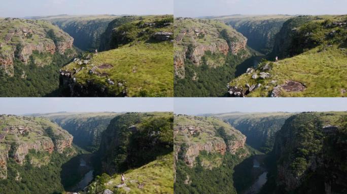 在南非东开普省姆坎巴蒂自然保护区观看宏伟的Msikaba峡谷的游客的鸟瞰图
