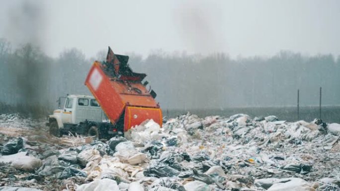 一台机器在垃圾填埋场工作，卸载垃圾。