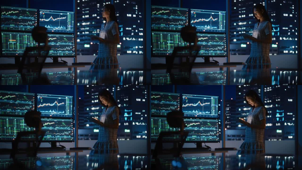 金融分析师使用平板电脑，站在多显示器工作站旁边，实时股票，商品和交易所市场图表。在投资银行城市办公室