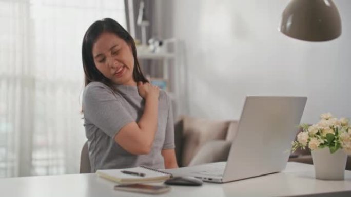 亚洲女商人在笔记本电脑上打字时颈部疼痛