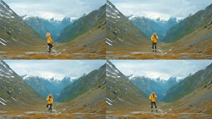 4k视频片段，一名年轻女子在Stryn探索山脉时兴奋地跳舞