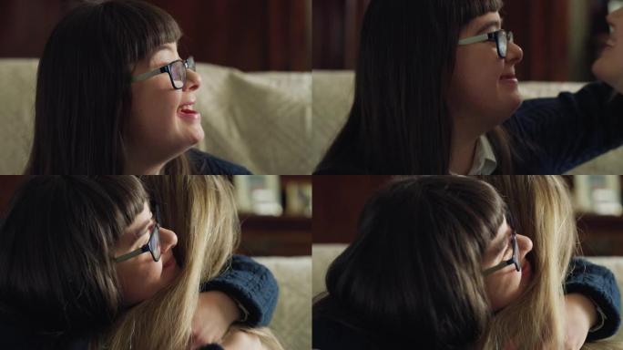 快乐的年轻女子坐在家里的沙发上深情拥抱患有唐氏综合症的少女妹妹的真实照片。爱情、家庭、残疾人、医疗保