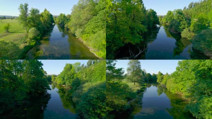 空中: 缓慢流动的河流，周围环绕着树木，蜿蜒穿过田野