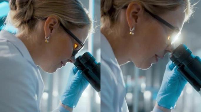 在明亮的医学科学实验室: 戴着眼镜的微生物学家在显微镜下观察分析样品。才华横溢的科学家，与高科技设备