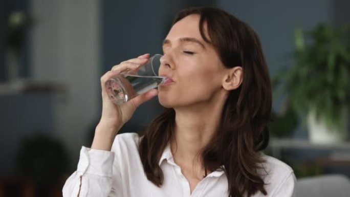特写镜头迷人的女人拿着玻璃饮料天然水