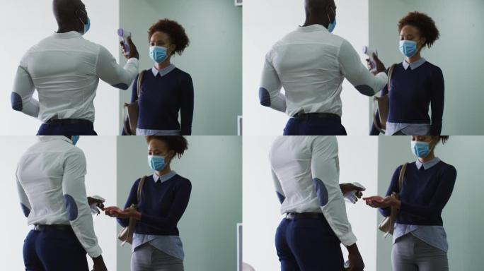 非裔美国商人戴着口罩消毒到达办公室的女同事的手