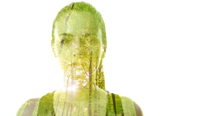 女士双重曝光了一位年轻女子的肖像，该肖像叠加在绿色森林上