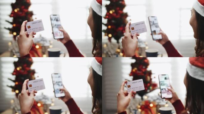 女人在圣诞节使用智能手机和卡片在线购买