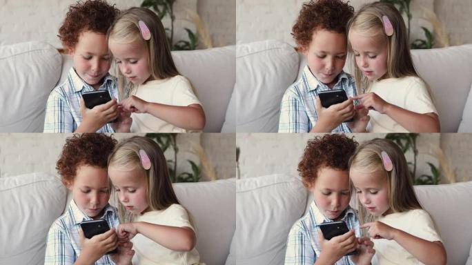 学龄前儿童坐在家里的沙发上使用智能手机