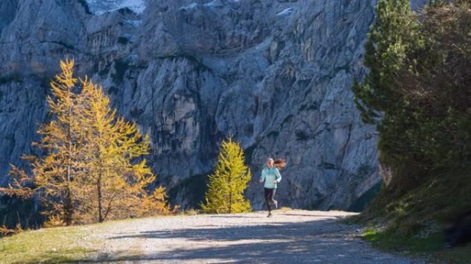 年轻的健身女子保持健康，在山上呼吸新鲜空气，慢跑