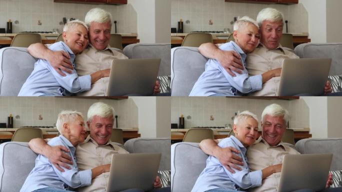 快乐的老奶奶爷爷笑在笔记本电脑上通过可视电话说话