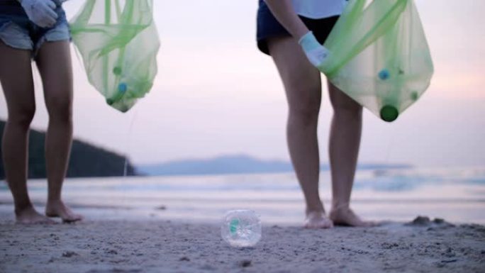 一群年轻女子在海滩上捡塑料瓶