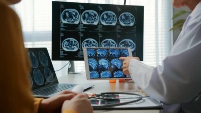 医生在数字平板电脑上显示脑部扫描