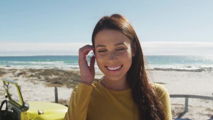 快乐的高加索女人站在海边的沙滩车附近