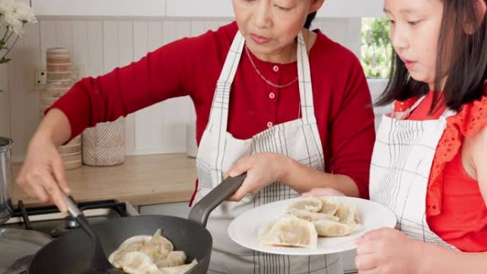 家庭，孩子和亚洲妇女和女孩一起在家里的厨房里煮饺子。食物，饭菜和美食，母女在房子里结为纽带时学习烹饪