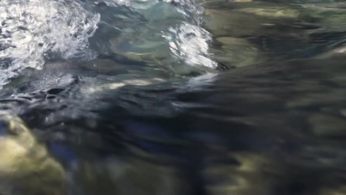 山河沸腾冷水的特写镜头。强劲的蓝色清澈水流在慢动作中。从水面射击