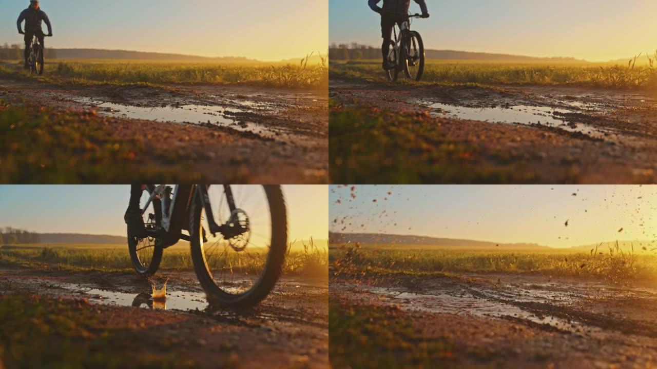 日落时分，SLO MO MTB骑自行车的人在草地之间的小路上穿过泥泞