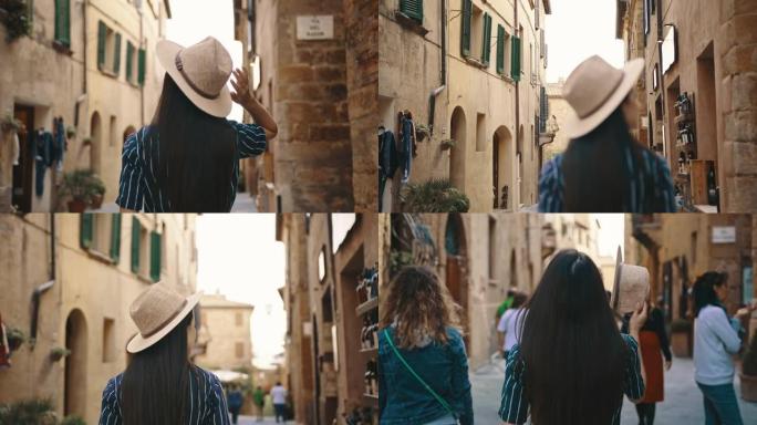 SLO MO女游客在皮恩扎 (Pienza) 的小巷中漫步时戴上遮阳帽
