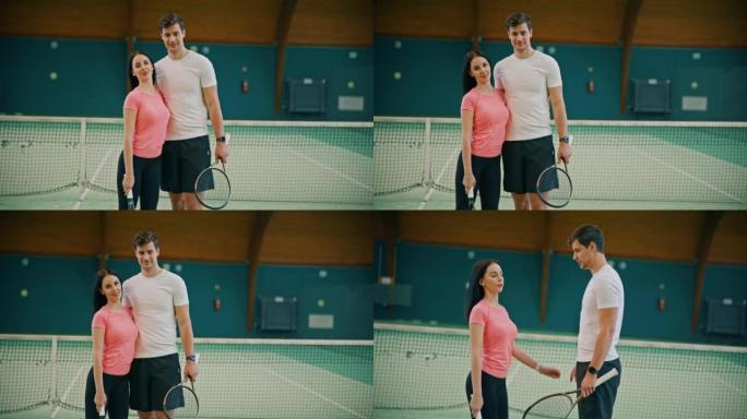 年轻的男教练和女人在网球场上双臂交叉站着