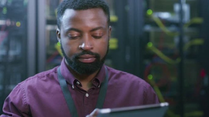 一个年轻人在服务器机房工作时使用数字平板电脑的4k视频片段