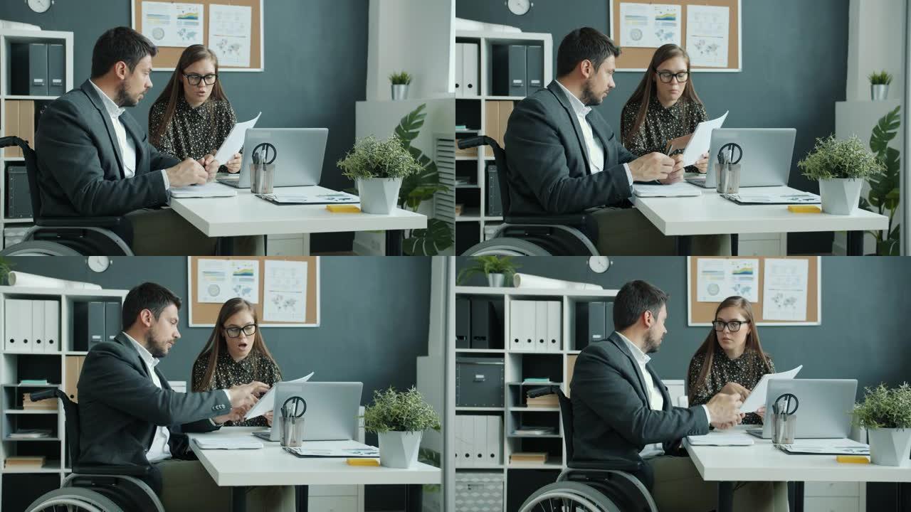 坐在轮椅上的开朗家伙与工作场所的女同事讨论工作