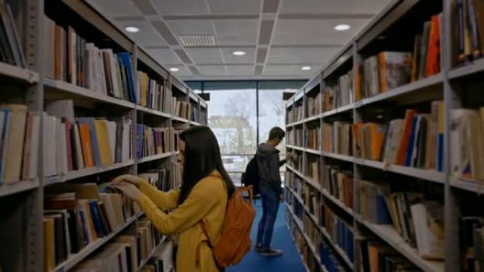 SLO MO两名学生在图书馆的书架上寻找书籍