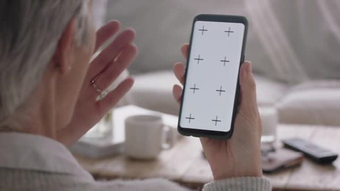 成熟的女人使用智能手机进行视频聊天绿屏聊天看起来很惊讶享受色度键显示垂直方向4k镜头上的移动通信