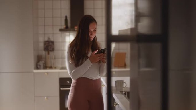 女人在厨房里使用智能手机