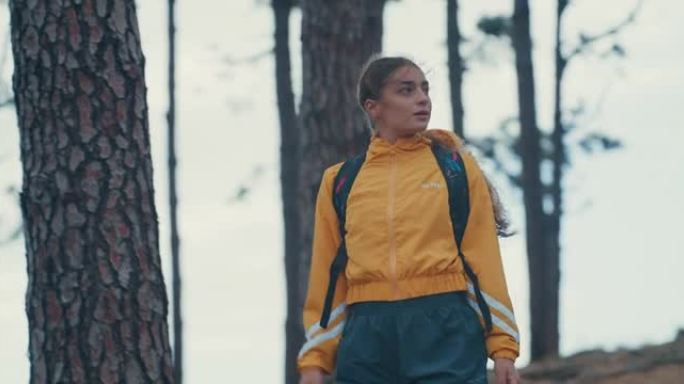 4k视频片段，一名年轻女子在远足时戴着背包