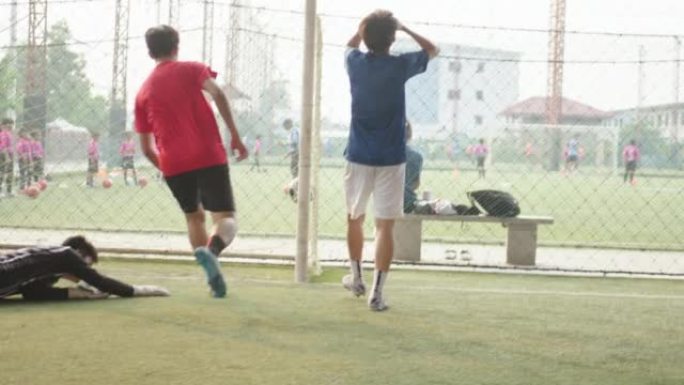 亚洲男子足球运动员与朋友一起打球。