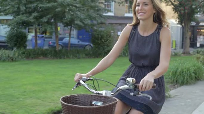 女商人骑自行车穿过城市公园