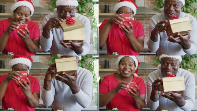圣诞节时戴着圣诞老人帽子的快乐非裔美国高级夫妇在视频通话中赠送礼物