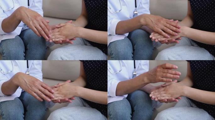 女医生握着和抚摸女人病人的手的特写