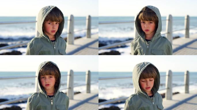 在葡萄牙的海滨长廊度假时，一个孩子在海滩上的悲伤、寒冷和脸。假期中遇到问题的男孩子的不幸，孤独和肖像