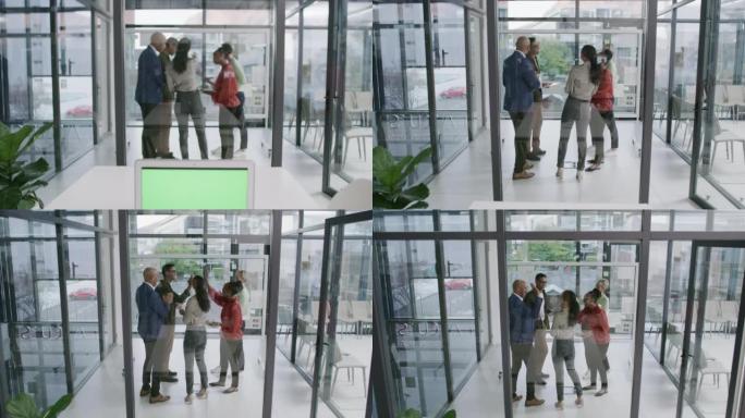 笔记本电脑显示绿屏复制空间，一群不同的商务人士在办公室的玻璃墙上进行计划和集思广益，背景为背景。宣传