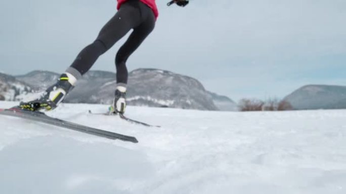 低角度: 专业的北欧滑雪运动员推下她的滑雪板和杆子。
