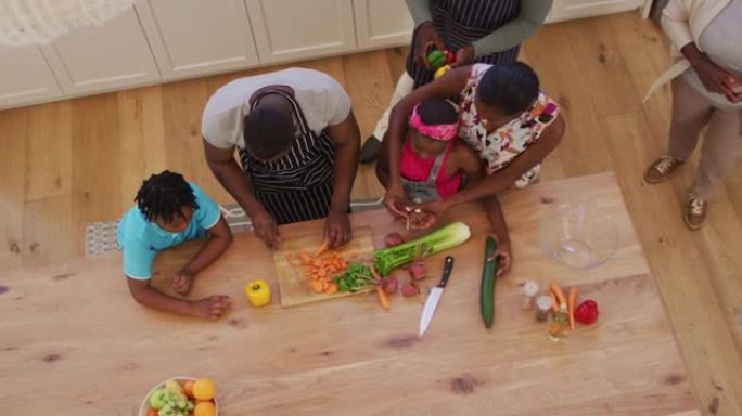 三代非洲裔美国人家庭在家中厨房切碎蔬菜的俯视图
