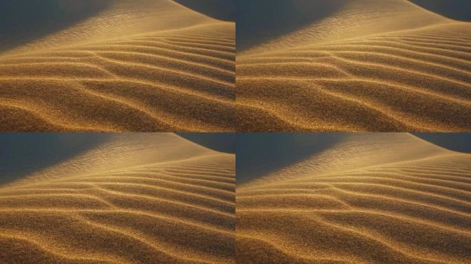 沙漠沙丘中的沙子随风飘动。沙粒沿着沙丘移动。沙漠中的日落。慢动作镜头