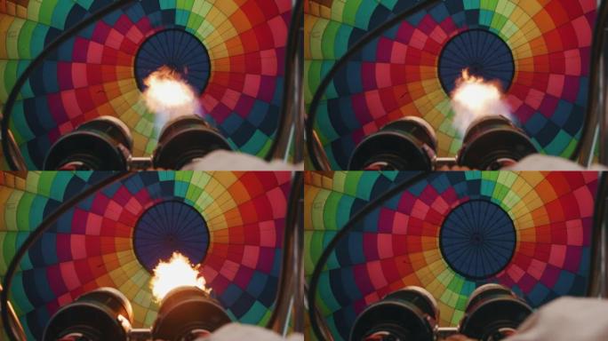 慢动作近距离观察飞行前正在充气的彩色热气球内部的火焰。