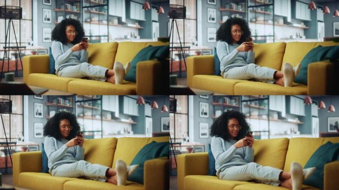 快乐美丽的拉丁女性在家里舒适的客厅使用智能手机。女性躺在舒适的沙发上。她正在浏览互联网，在社交网络上