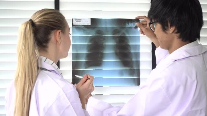 医生与团队一起分析医学上的肺部x射线图像胶片